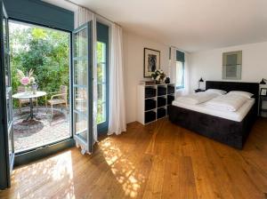 a bedroom with a bed and a sliding glass door at Boutique Garden Studio in Kreuzlingen +5 photos