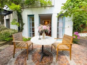 a table with two chairs and a vase with flowers at Boutique Garden Studio in Kreuzlingen