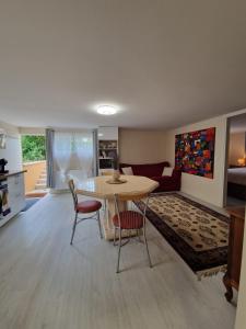 a kitchen and living room with a table and chairs at Le Jardin de Courcelle in Gif-sur-Yvette