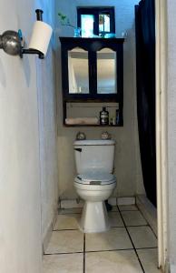 a bathroom with a toilet and a window at Cativa CozyHomestay in Hermosillo