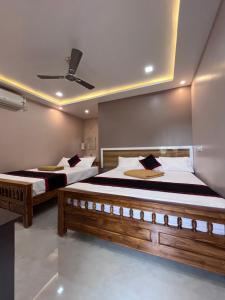 a bedroom with two beds and a ceiling at VV Guest House & Rooms in Tiruvannāmalai