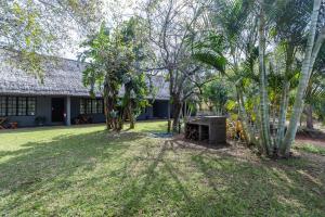 a house with a yard with trees and a building at Ndumu Safari Resorts in Jozini