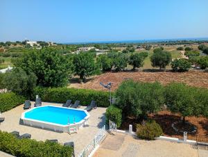 an overhead view of a swimming pool with chairs and trees at Villa Chirilú in Polignano a Mare