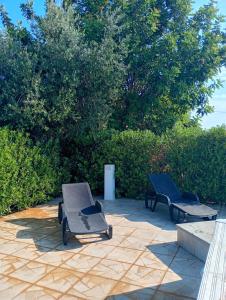 a patio with two chairs and a table and benches at Villa Chirilú in Polignano a Mare +14 photos