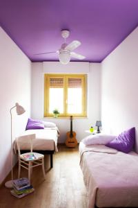 a bedroom with two beds and a purple ceiling at Arcobaleno B&B in San Benedetto del Tronto