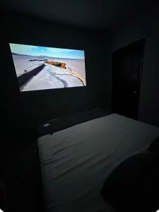 a tv screen in a dark room with a bed at Suite Brisa da Colina in Garanhuns