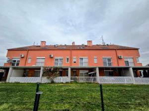 a large orange house with a fence in front of it at DenVigo in Čakovec