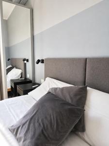 a bedroom with a white bed and a mirror at Suite Panoramica - Novara Centro in Novara