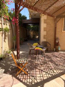 a patio with a table and chairs under a pergola at Villa agamy in Burj al ‘Arab al Jadīdah