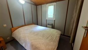 a small bed in a small room with a window at Chalet LE LIRY in Tournavaux +13 photos