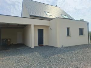 a white building with a blue door on it at Maison Du Bonheur in Erquy