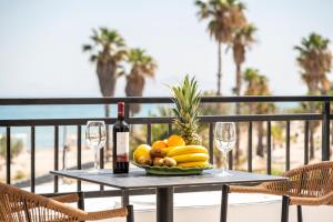 a table with a bowl of fruit and two wine glasses at Stella Maris in Kos