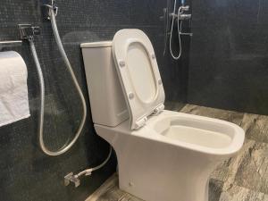a white toilet in a bathroom with a shower at Elysian Riverside in Weligama +12 photos