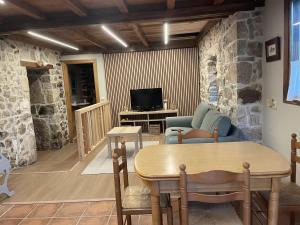 a living room with a table and a tv at Casa del Tesoro II in Cangas de Onís