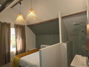 a bedroom with a bed and a sink and two lights at Cyprès des Vignes- L'Ecrin in Hermonville