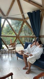 three people laying on a couch in a room at Chalés Pura Vida in Itacaré