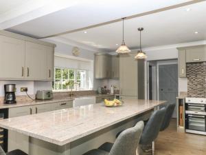 a kitchen with a large marble counter top and chairs at The White House in Okehampton