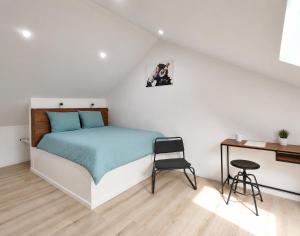 a bedroom with a bed and a desk and a chair at Le temps d'une pause -1- in Cepoy +8 photos