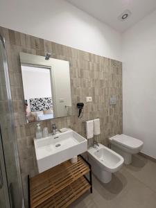 a bathroom with a sink and a toilet and a mirror at I Tetti di Siciliando in Modica