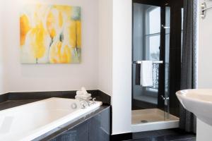 a bathroom with a bath tub and a sink at Hotel Le Saint-Paul in Quebec City