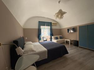 a bedroom with a bed and a chair and a window at I Tetti di Siciliando in Modica