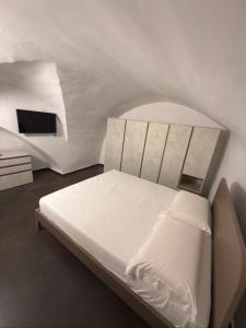 a bedroom with a white bed and a tv at Moira Luxury Appartament in Bitonto