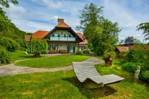 a green and white house with a bench in the yard at Hirschenhof in Graz