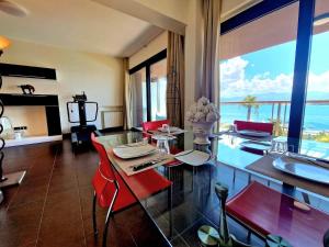 a living room with red chairs and a glass table at Milazzo. Intero alloggio in affitto in Milazzo