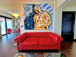 a red couch in a living room with a painting at Milazzo. Intero alloggio in affitto in Milazzo +11 photos