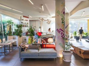 ein Wohnzimmer mit einer Couch und einigen Pflanzen in der Unterkunft ibis Styles Catania Acireale in Acireale