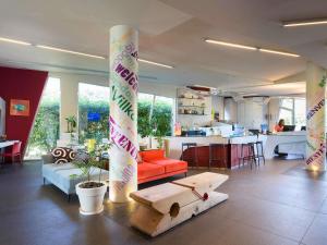 ein Wohnzimmer mit einem Tisch in der Mitte des Raumes in der Unterkunft ibis Styles Catania Acireale in Acireale