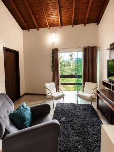 a living room with a couch and chairs and a piano at O melhor de Garopaba in Garopaba