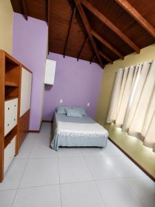 a bedroom with purple walls and a bed in a room at O melhor de Garopaba in Garopaba
