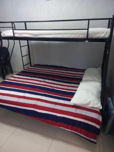 a bunk bed with a red white and blue striped blanket at Ocean Wave Chalets Unit 1 in Hibberdene +12 photos