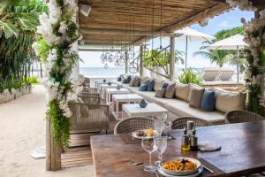 a restaurant on the beach with tables and chairs at Preabeach Boutique Hotel & SPA in Prea