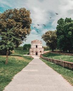 an old stone building with birds flying in the sky at Classense House in Classe