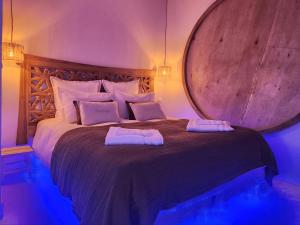 a bedroom with a large bed with two pillows on it at Suite Amoriya in Camblanes-et-Meynac