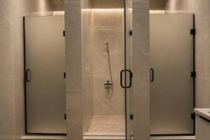 a shower with glass doors in a bathroom at Nomad Aktau Hostel in Aktau