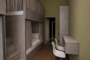a bedroom with a bunk bed and a white chair at Nomad Aktau Hostel in Aktau +15 photos