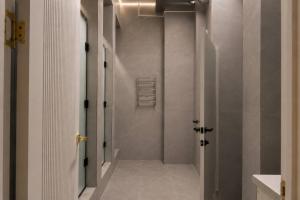 a bathroom with a walk in shower with white walls at Nomad Aktau Hostel in Aktau