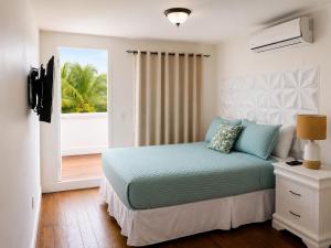 a bedroom with a bed and a large window at Solea by The Sea in Roatán