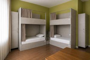two bunk beds in a room with green walls at Nomad Aktau Hostel in Aktau