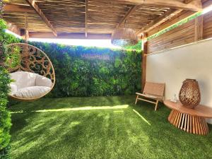 a room with green grass and a patio with a swing at Suite Amoriya in Camblanes-et-Meynac