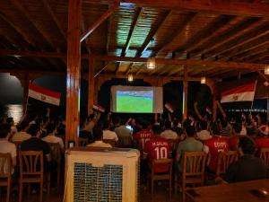 a crowd of people sitting in a room with a screen at Mermaid camp in Nuweiba