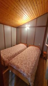 two beds in a small room with wooden walls at Chalet LE BAUSOY in Tournavaux +13 photos