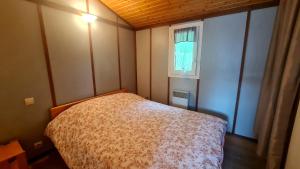 a small bedroom with a bed and a window at Chalet LE BAUSOY in Tournavaux