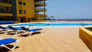 a pool with lounge chairs and a hotel at 525 Aguamarina in San Miguel de Abona