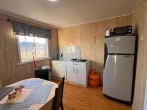 a kitchen with a refrigerator and a table and a window at CasasAnique in Cañete