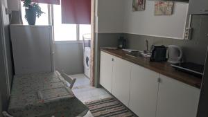 a kitchen with a refrigerator and a counter top at Vasco Santana Guesthouse in Odivelas