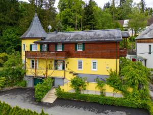 a yellow house with a gray roof at Hans Mauracher Schlössl in Graz